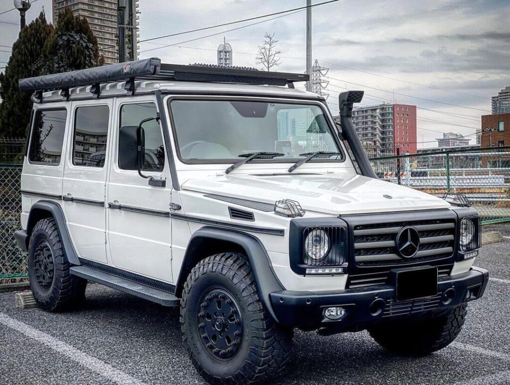 White Mercedes G Class with a snorkel and an awning