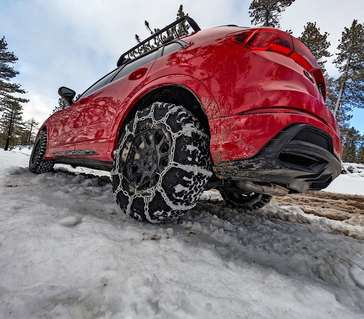 Audi Q3 S-line with snow chains on rear wheels to drive uphill in the snow