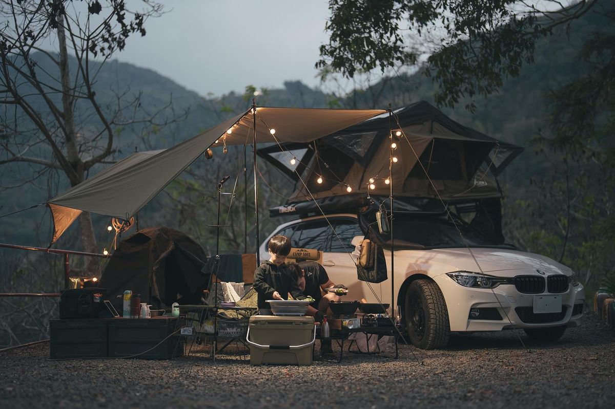 White BMW F31 3 Series overland wagon at a campsite with a Timebox rooftop tent deployed