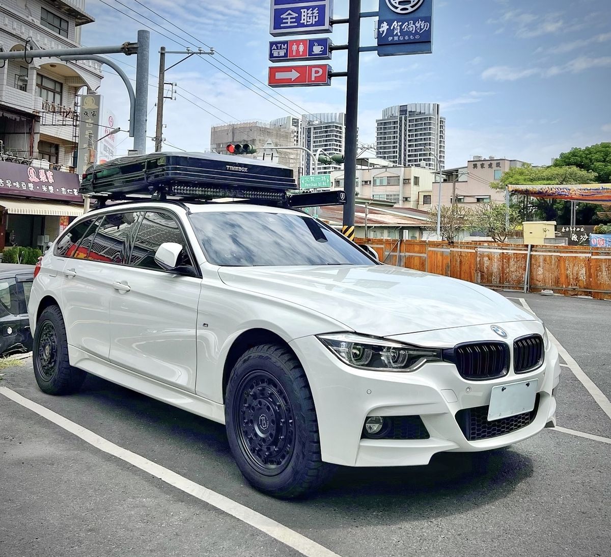 Timebox rooftop box in closed position on a white BMW F31 M Sport Touring on city street