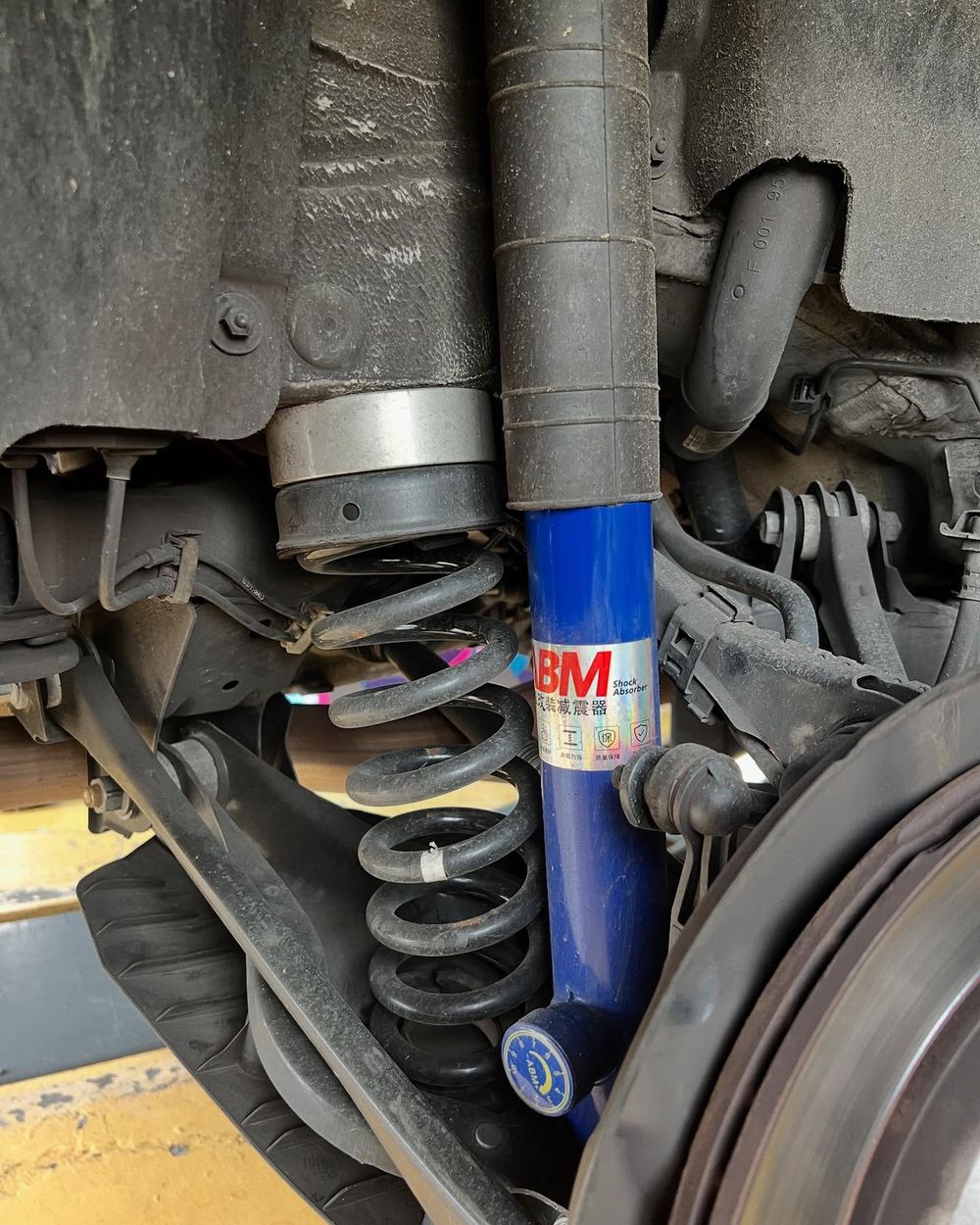 ABM shock absorber close-up showing blue body and coil spring