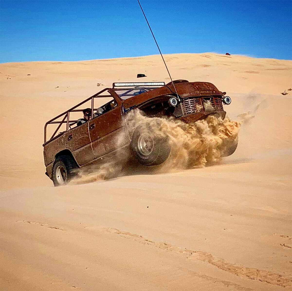 Jumbing dunes in a rat rod buggy