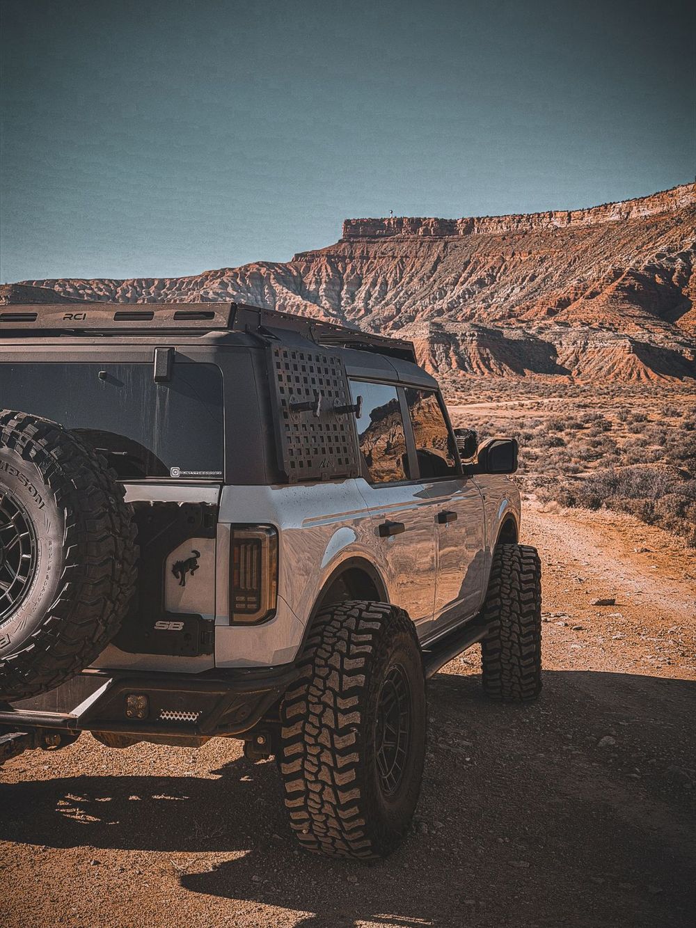 RCI full-length aluminum roof rack installed on a gray Ford Bronco on a canyon trail