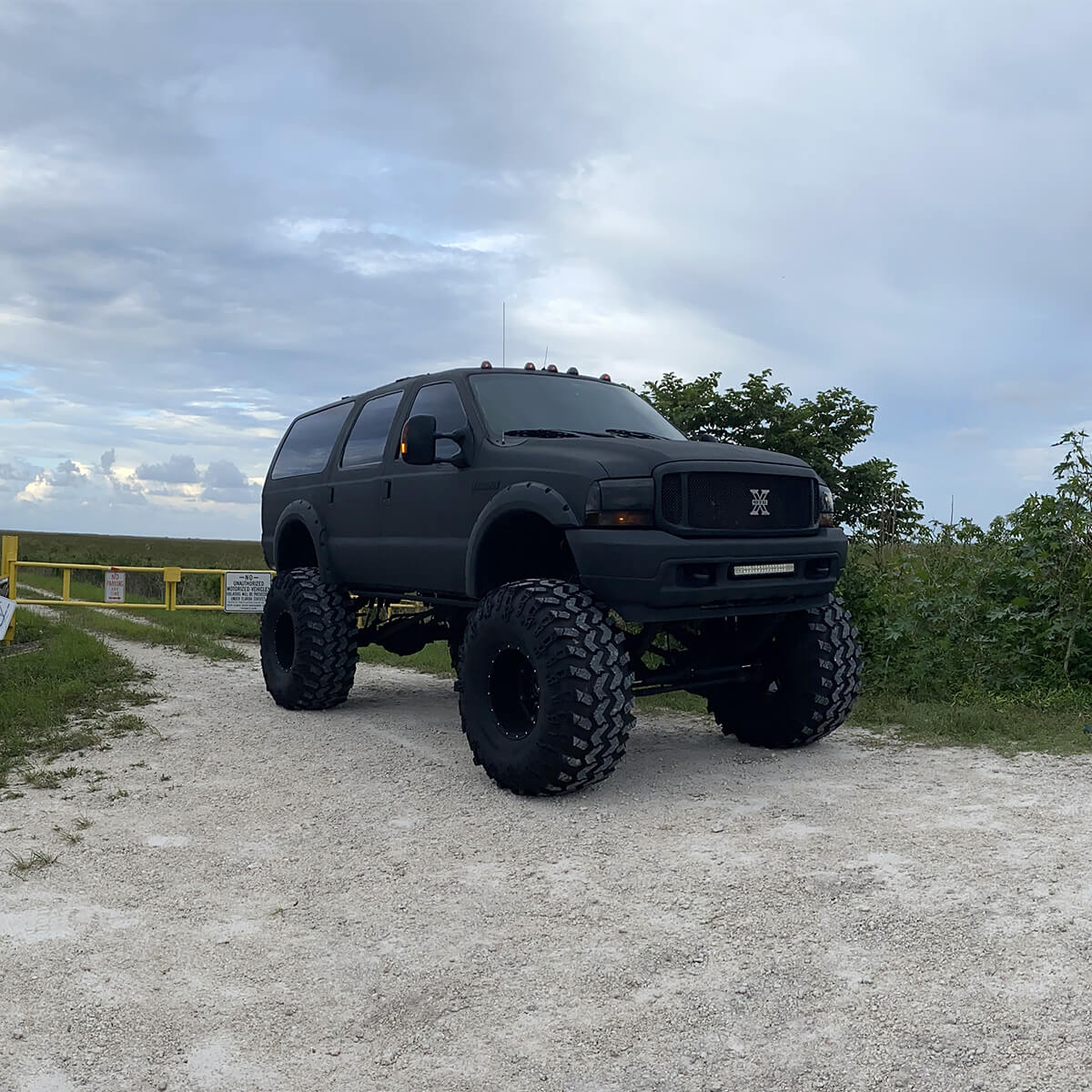 Matte black Ford Excursion lifted truck on 49" super Swamper tires
