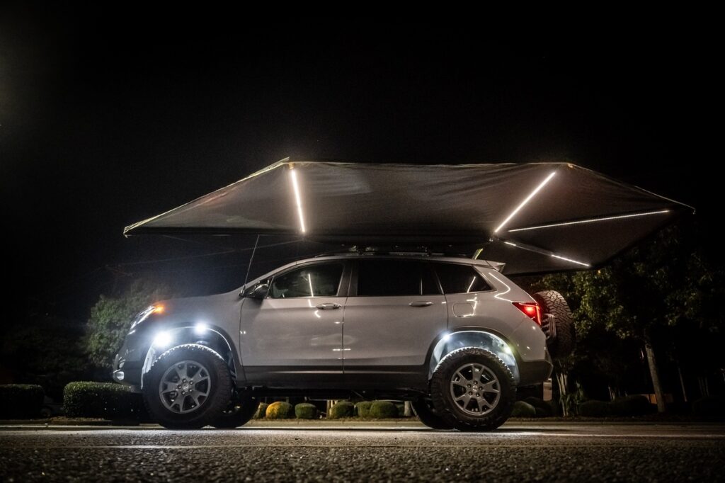 270-degree freestanding awning deployed from a Honda Passport TrailSport at night