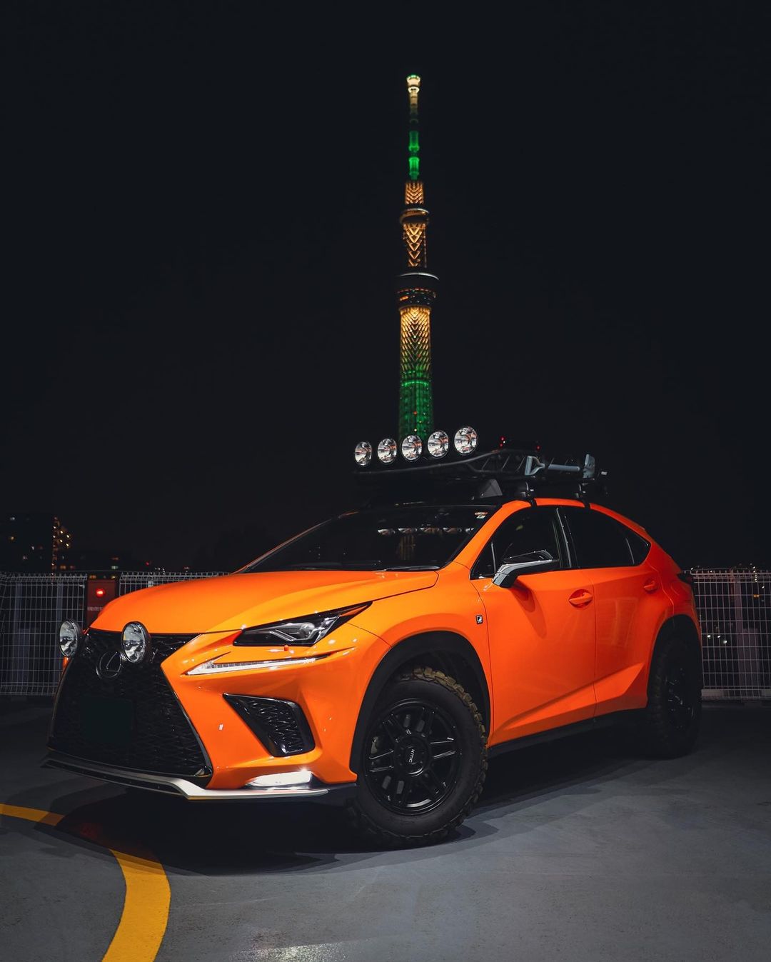 Lexus NX300 F-Sport in orange with a roof rack and LED lights