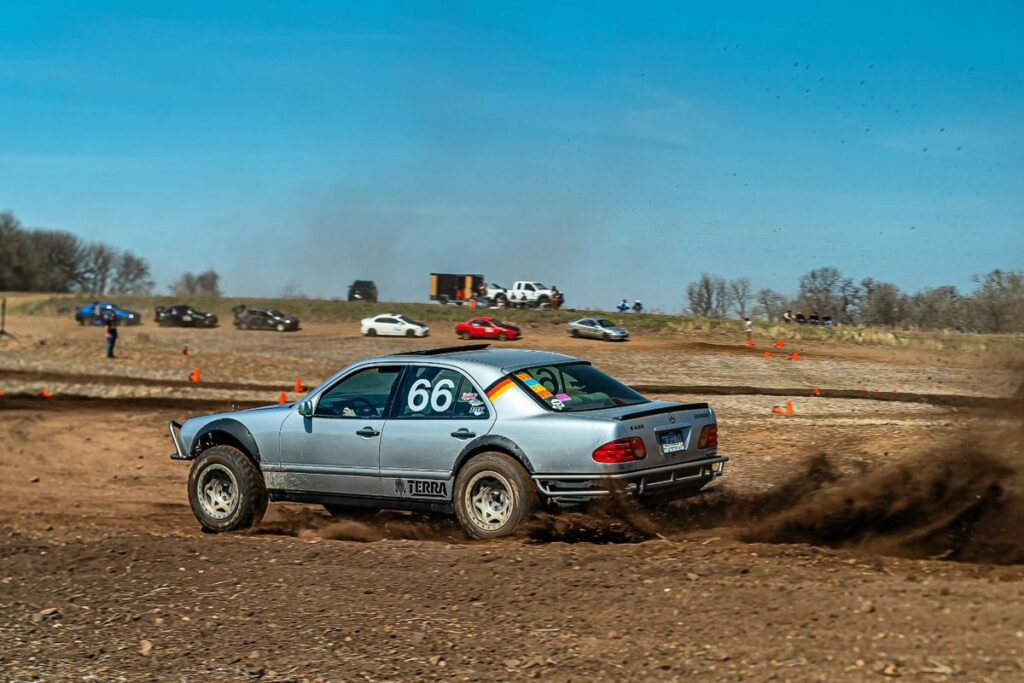 1998 silver Mercedes W210 prerunner number 66 racing on a dirt autocross course