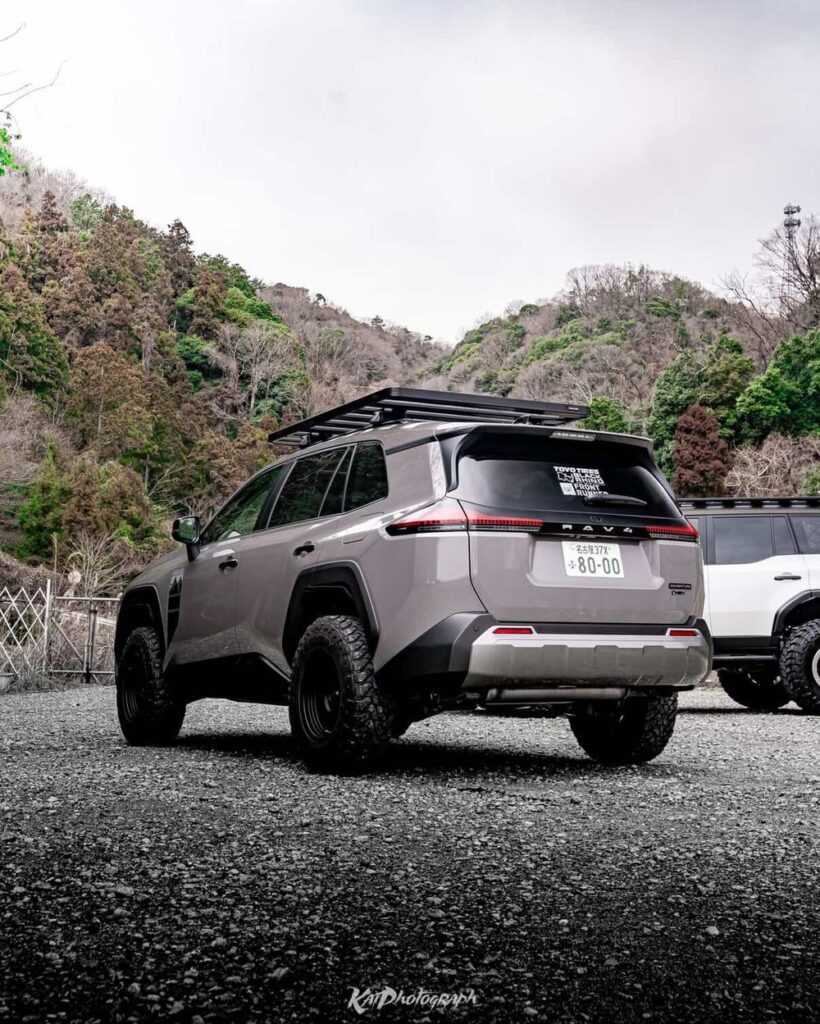 Rear three-quarter view of a lifted 6th gen RAV4 showing RAV4 badge on tailgate