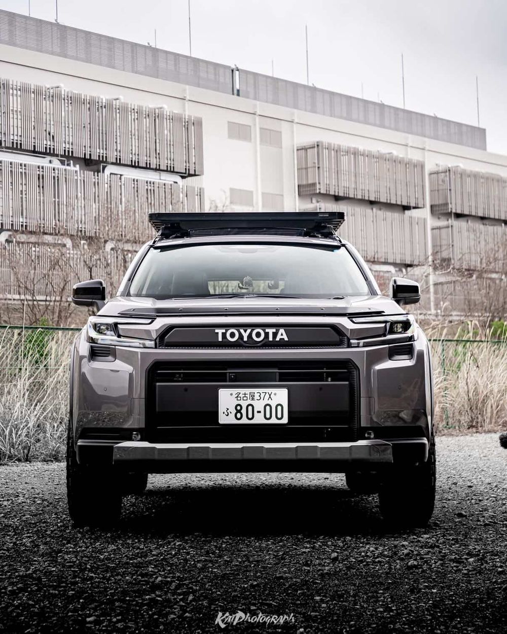 Straight-on front view of a gray 2026 Toyota RAV4 6th gen with a genuine hood deflector