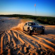 Mercedes E-Class sand offroading through the dunes of a desert