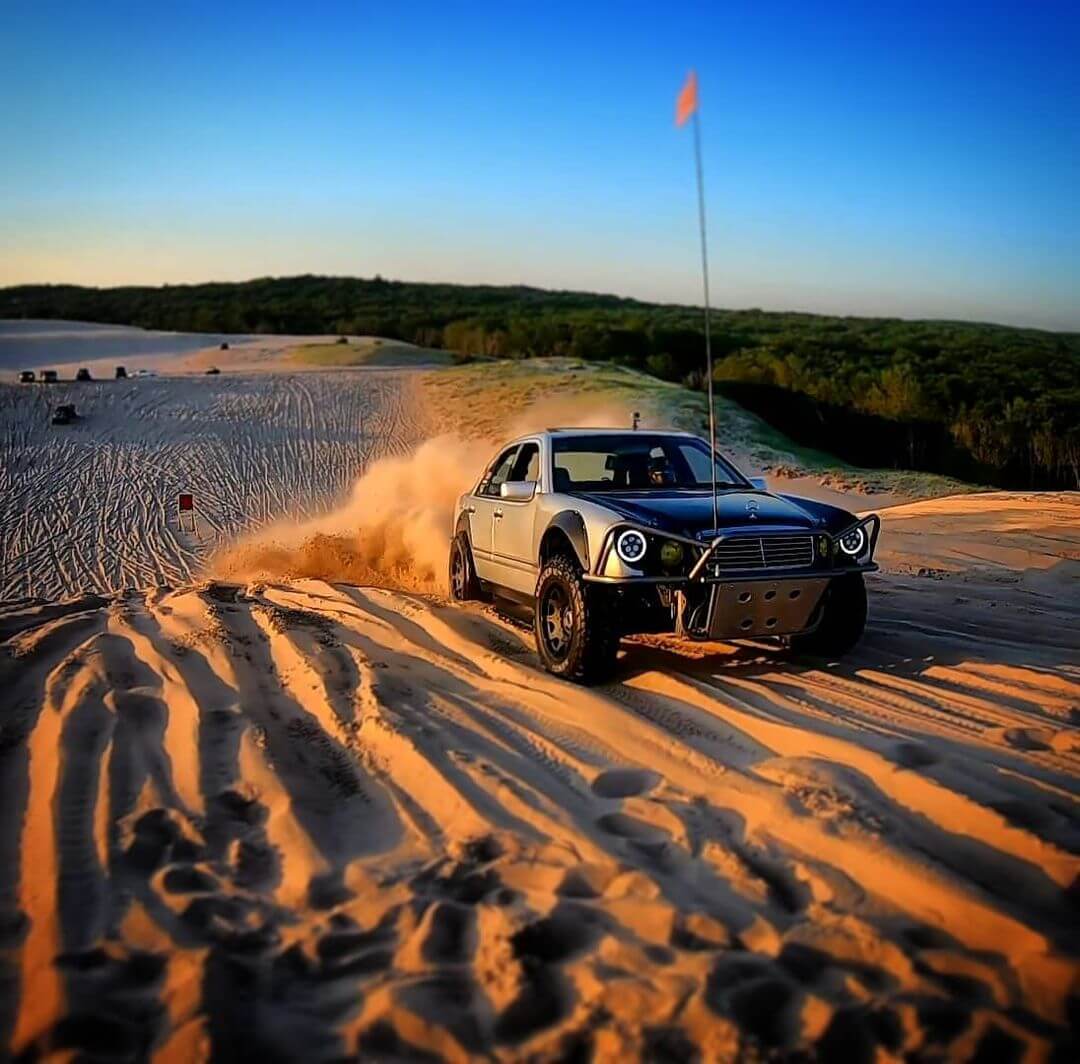 Mercedes E-Class sand offroading through the dunes of a desert