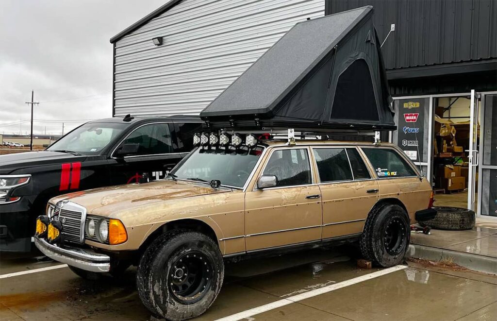 Lifted Mercedes W123 off-road overland wagon with a roof top tent