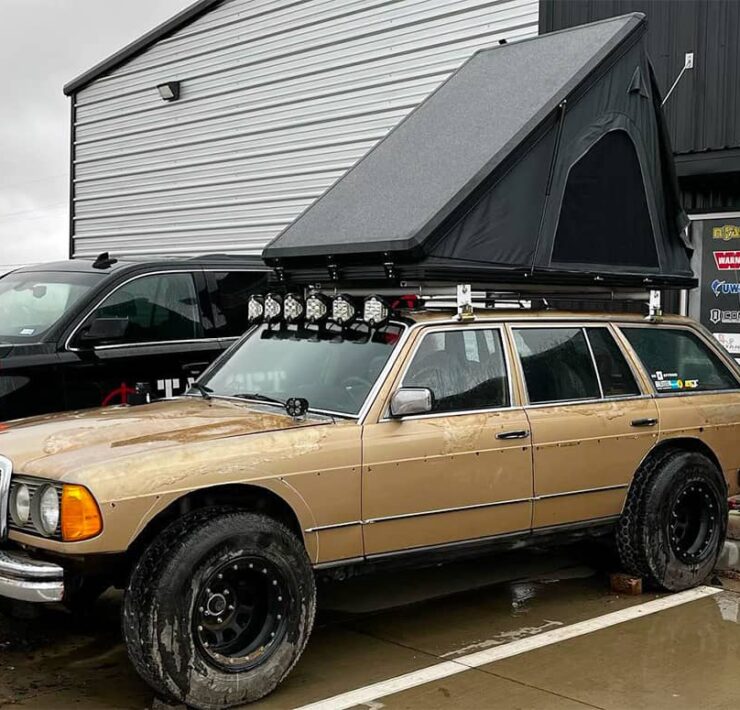 Lifted Mercedes W123 off-road overland wagon with a roof top tent