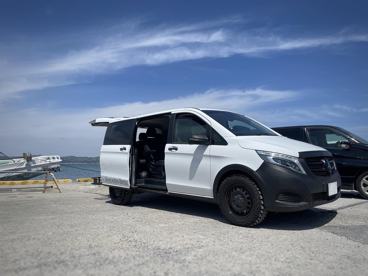 White Mercedes W447 V-Class with sliding door open showing interior space for camping
