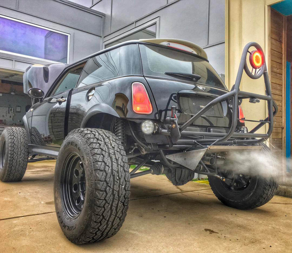 Mini Cooper with a custom fabricated long travel suspension and a full-size spare tire carrier