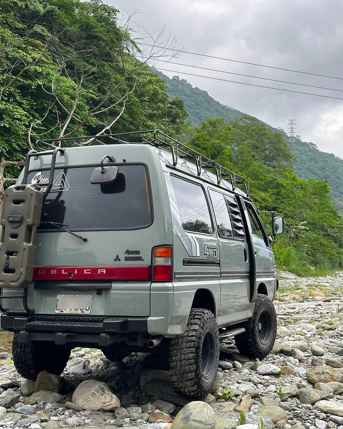 Grey 1996 Mitsubishi Delica L300 off-road build with a ladder and roof rack