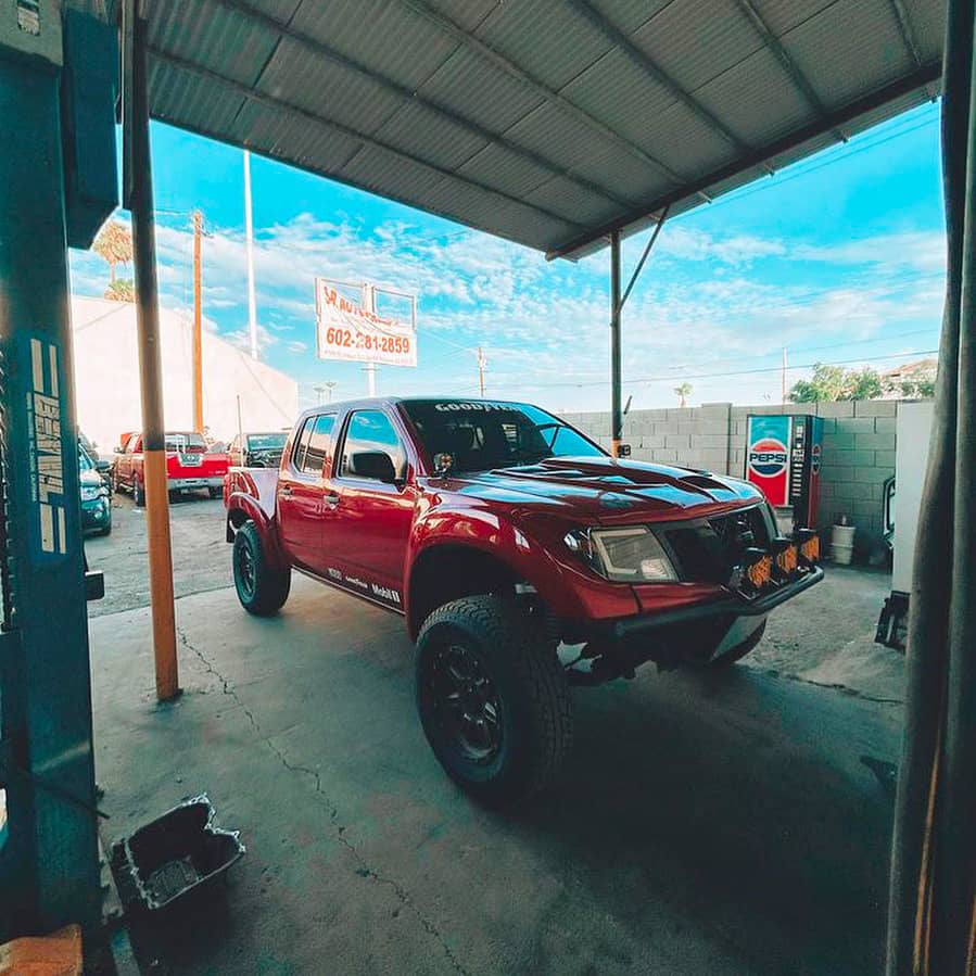 Red Nissan Frontier prerunner truck build with 33 inch tires and Black LED custom headlights by Spyder