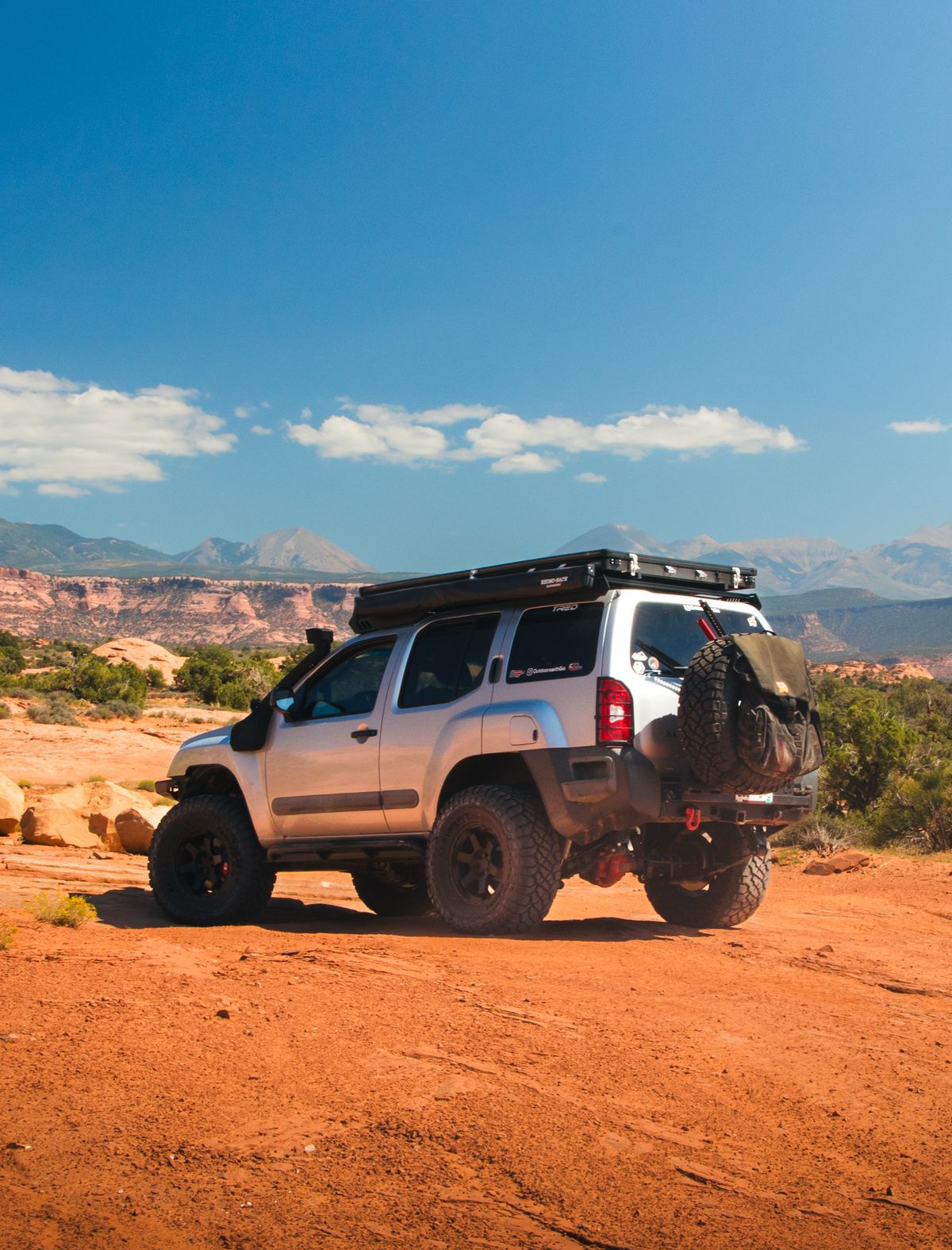 2nd Gen Nissan Xterra with a Rhino-Rack roof rack on red desert slickrock near Moab Utah