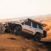 Silver 2nd Gen Nissan Xterra climbing steep Moab slickrock showing Z1 Offroad ATK-06 wheels