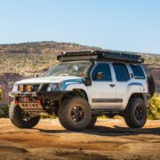 Silver 2005–2015 Nissan Xterra Titan Swap build posed on desert rock under clear blue sky