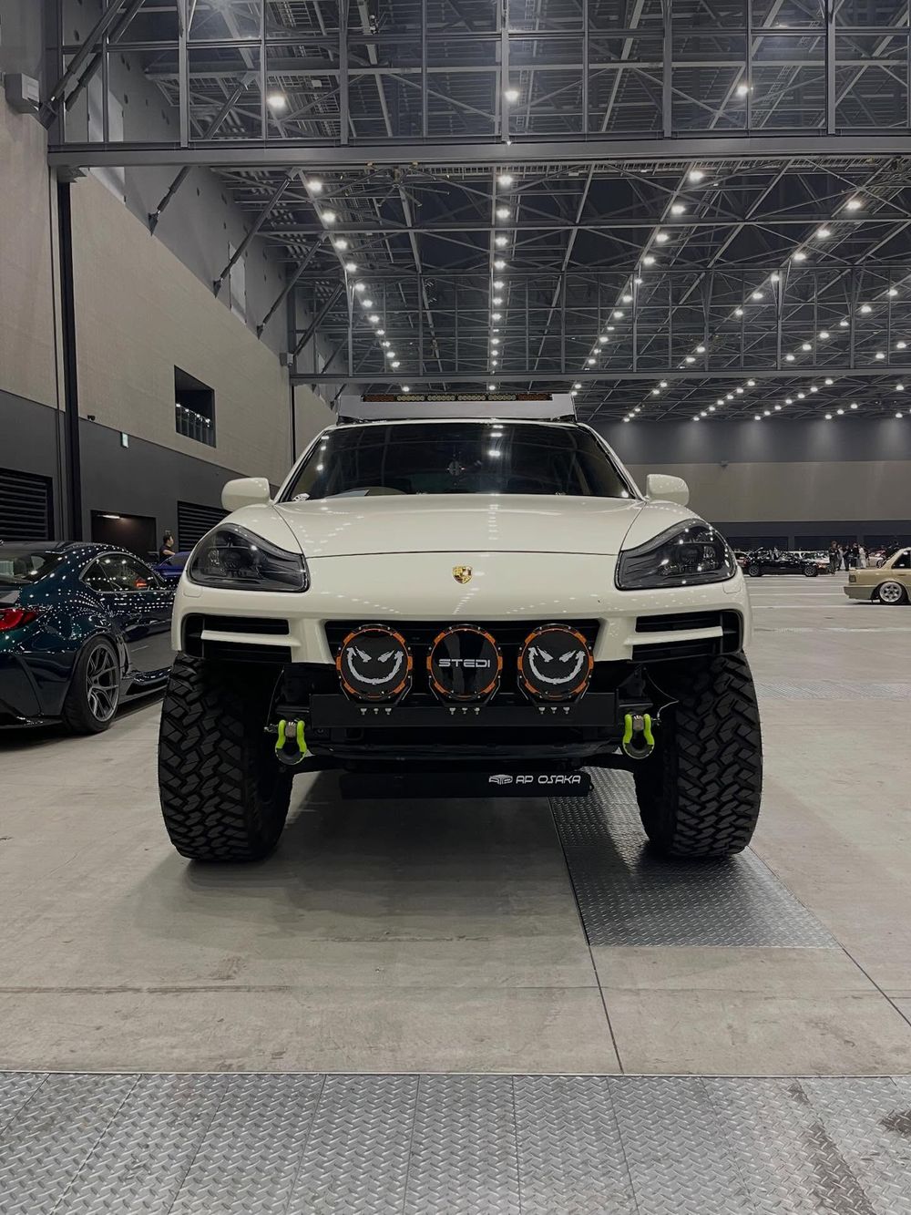 White lifted Porsche Cayenne with AP Osaka front bumper on display at a Japanese car show