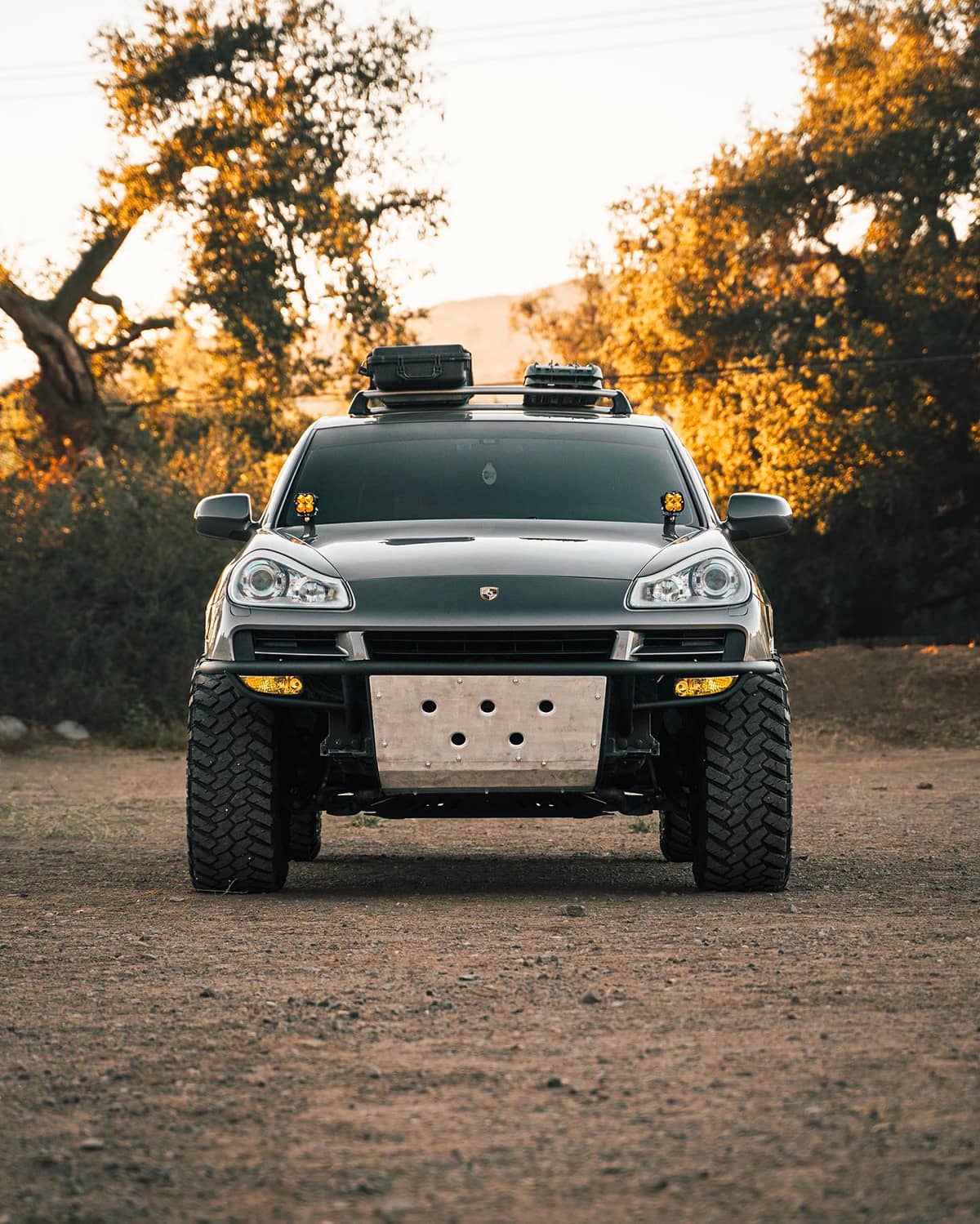 Lifted Porsche Cayenne 957 pre-runner style off-road bumper with a skid plate and amber pod lights