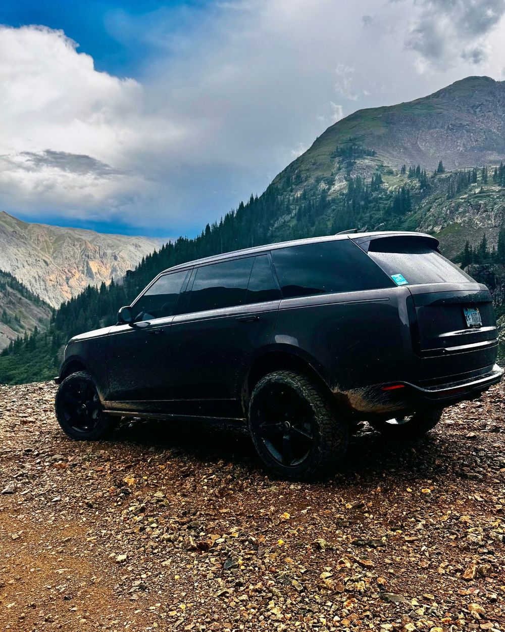 2023 Range Rover L460 in gloss black on a rocky mountain trail