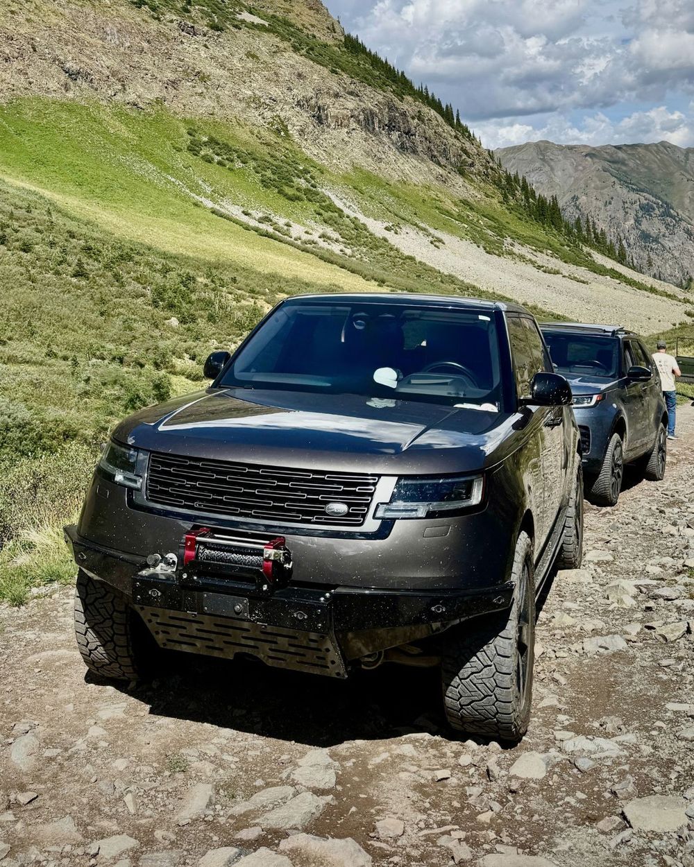 2023 Range Rover L460 SE LWB in dark gray tackling a rocky off-road trail