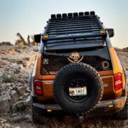 Rigid Armor drop-down full-size spare tire carrier for recovery purposes. The roof rack is made by DV8 Offroad.