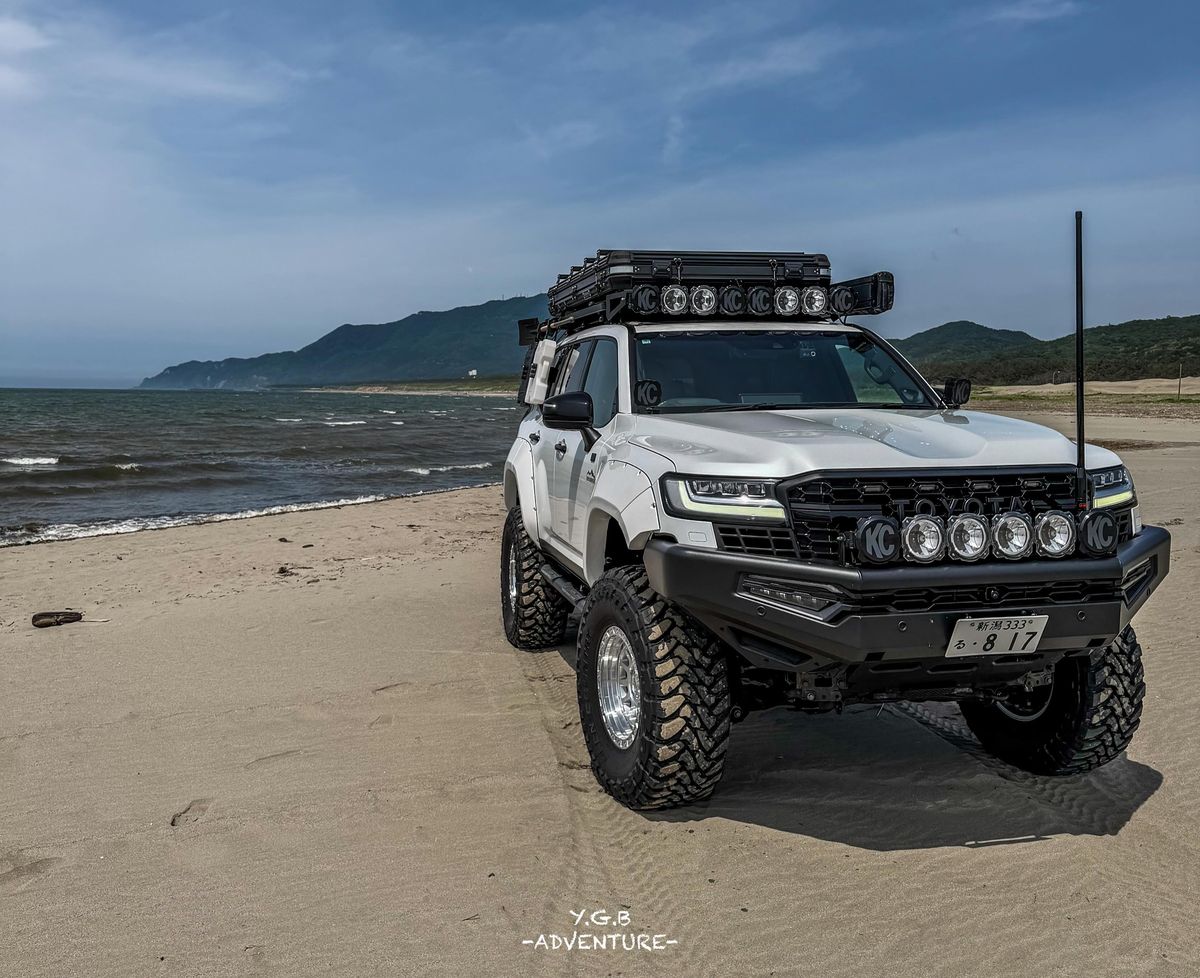 2022 Toyota Land Cruiser 300 Series in white on a sandy beach with 37-inch mud terrain tires