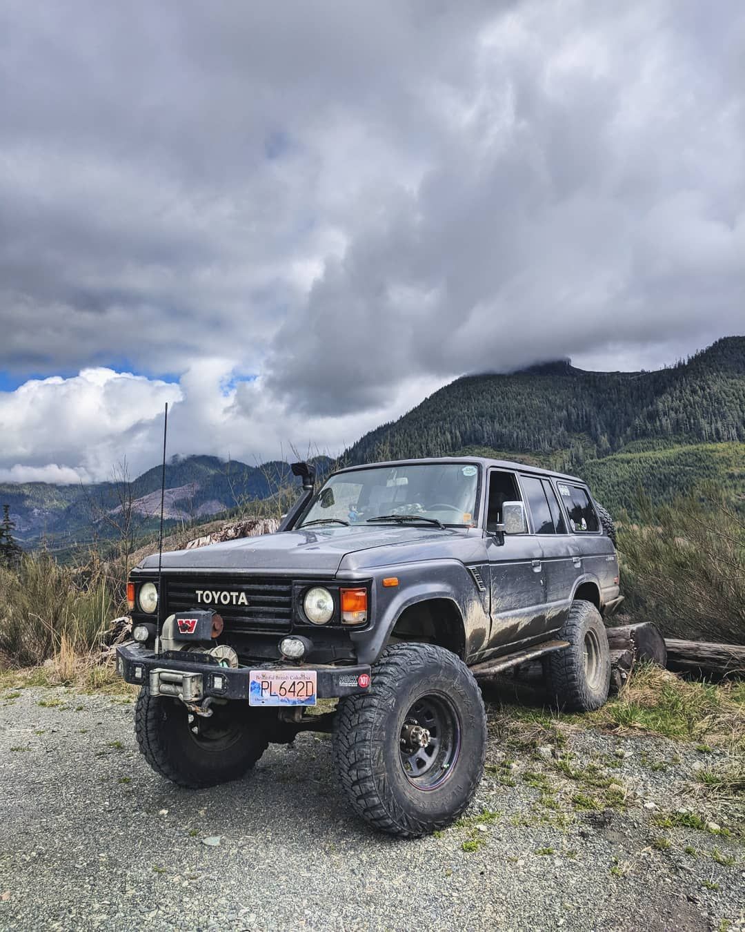 Custom 17-inch steel rims with 3.75-inch backspacing on a lifted FJ60 Land Cruiser in the mountains
