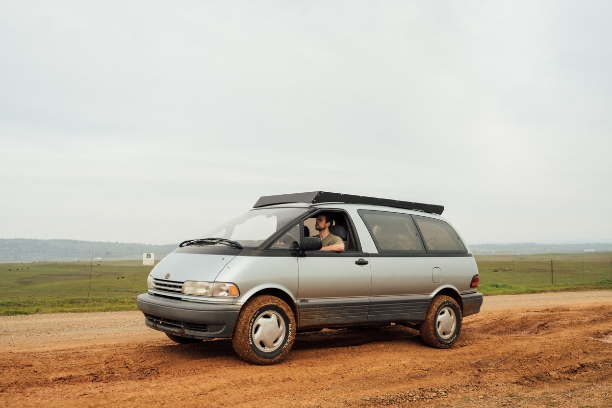 1994 silver Toyota Previa Alltrac driving a muddy dirt road with a 2 inch lift kit