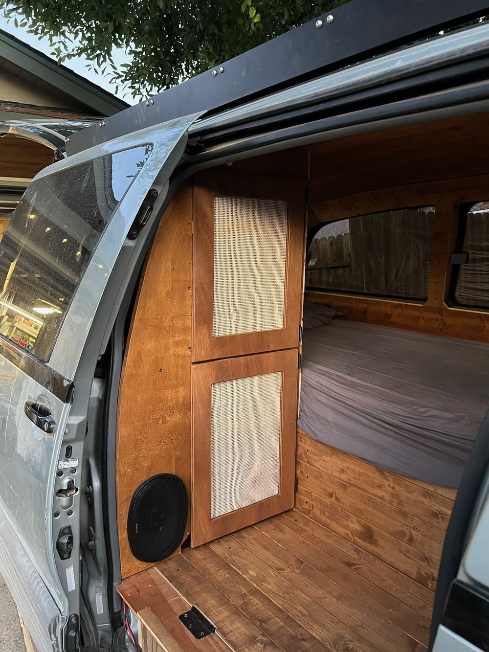 Pine tongue-and-groove interior cabinets with walnut stain and a subwoofer inside a Toyota Previa