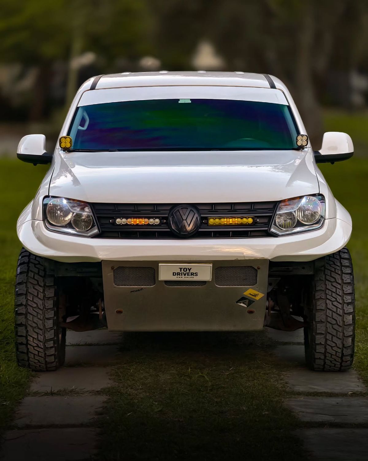 Baja Designs OnX S8 light bar mounted in the grille of a white VW Amarok rally raid truck