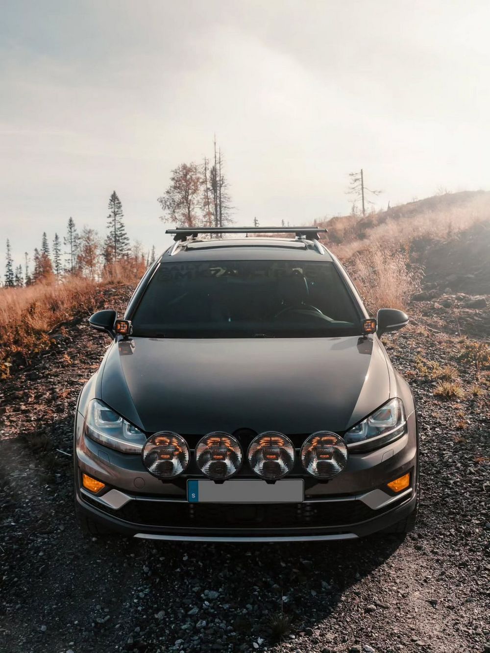 Modified VW Golf Alltrack with four Strands LED off-road lights mounted on front grille on forest trail