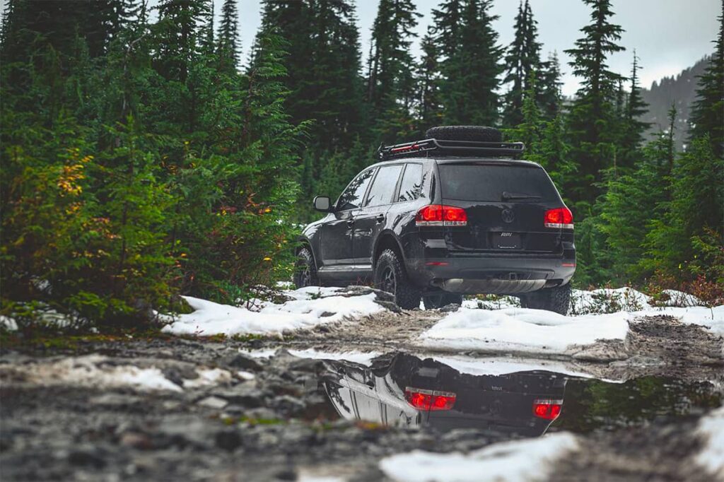 Black VW Touateg mk1 offroading in the forest